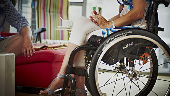 close-up-of-woman-in-a-wheelchair-talking-with-a-male-friend_575x325