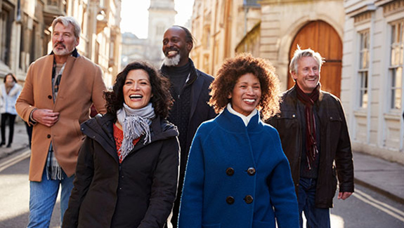 five-smiling-people-in-warm-jackets-walking-down-european-street-international-educational-resources