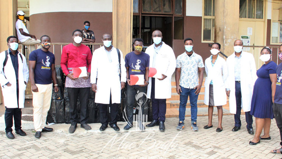 a-group-of-men-and-women-in-lab-coats-and-masks