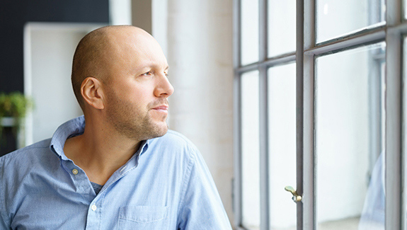 man-looking-out-window-six-types-of-urinary-incontinence