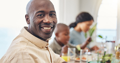 portrait-of-smiling-man-dining-with-family-living-with-an-ostomy_480x250