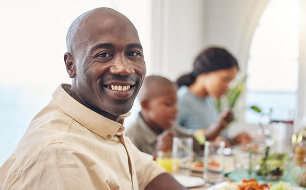 portrait-of-smiling-man-dining-with-family-living-with-an-ostomy_450x280