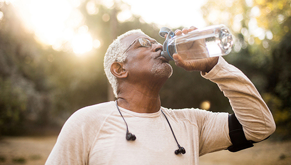 man-drinking-water-maintaining-skin-moisture_575x325