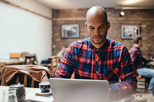 man-using-laptop-in-coffee-shop-understanding-intermittent-catheterization_495x328