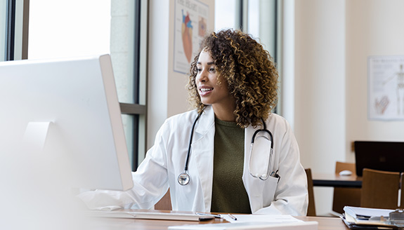 clinician-at-desk-working-on-laptop-Hollister-convexity-case-studies-575x325