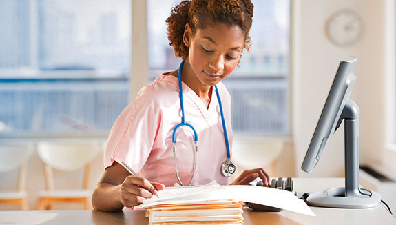 clinician-in-office-reviewing-files-Hollister-ostomy-online-course-575x325