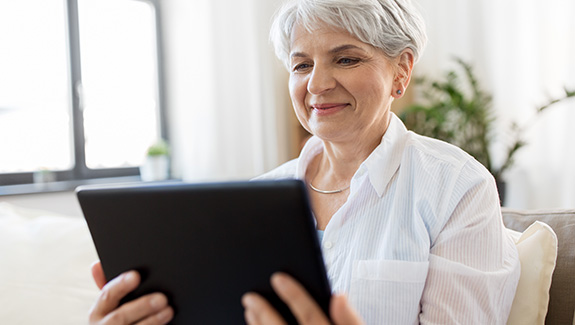 woman-holding-and-watching-tablet-Hollister-peristomal-skin-health-webinar-series-575x325