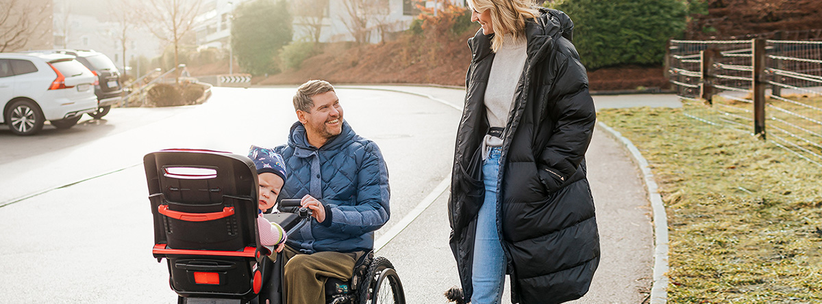man-in-wheelchair-in-park-with-family-Hollister-Continence-Care_1200x454
