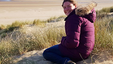 Alice-podcast-image-smiling-woman-kneeling-on-beach