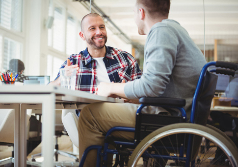 man-in-wheelchair-talking-to-friend-at-table_485x342